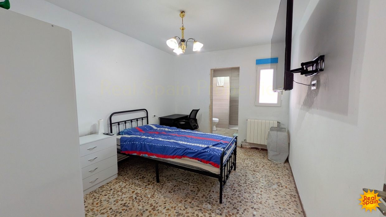 Bedroom at Cortijo Salud with a metal bedframe and wall-mounted television