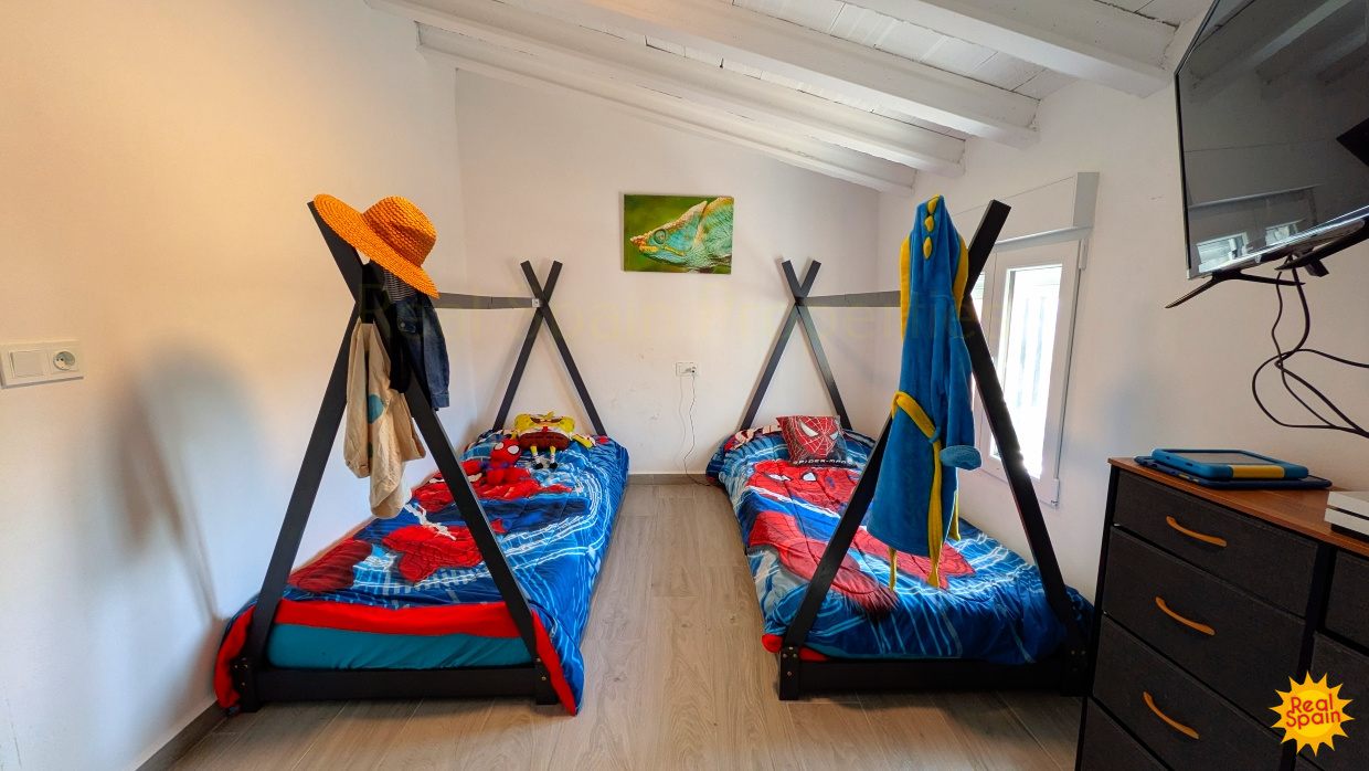 Bunk bedroom at Cortijo Salud with desks and wall-mounted television