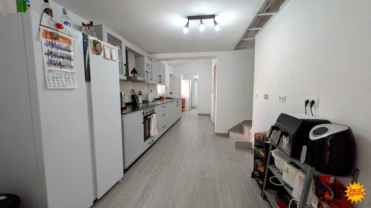 Long view of the kitchen at Cortijo Salud with fridge, worktops and storage