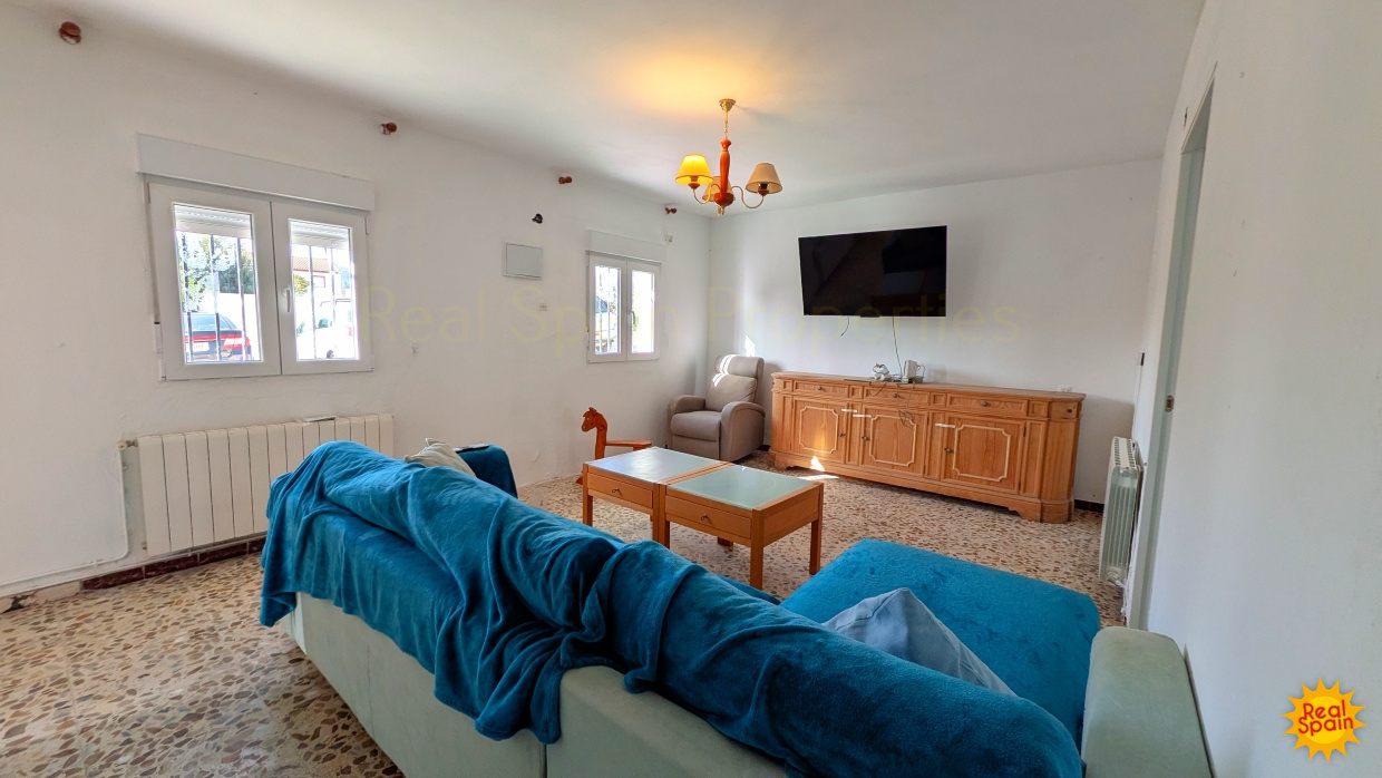Living area at Cortijo Salud with sofa, television and central heating radiator