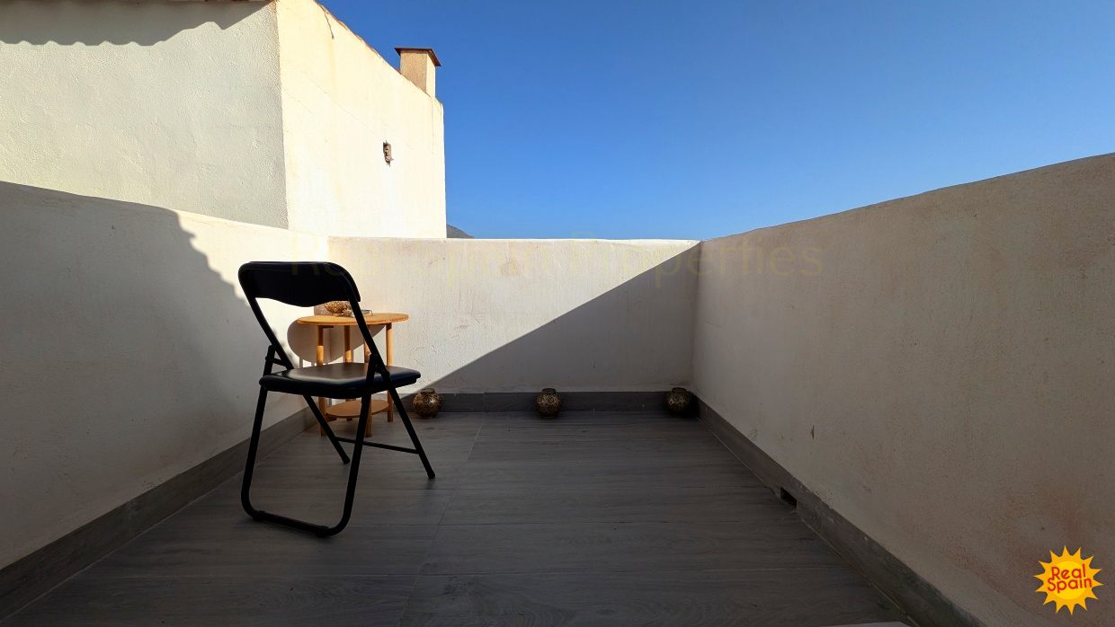 Small terrace at Cortijo Salud with white walls and a simple chair