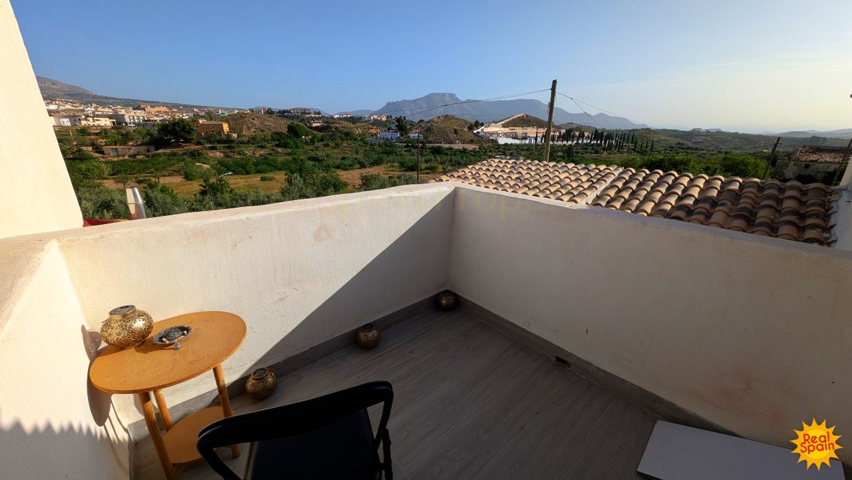 Upper terrace at Cortijo Salud with views over nearby rooftops and countryside